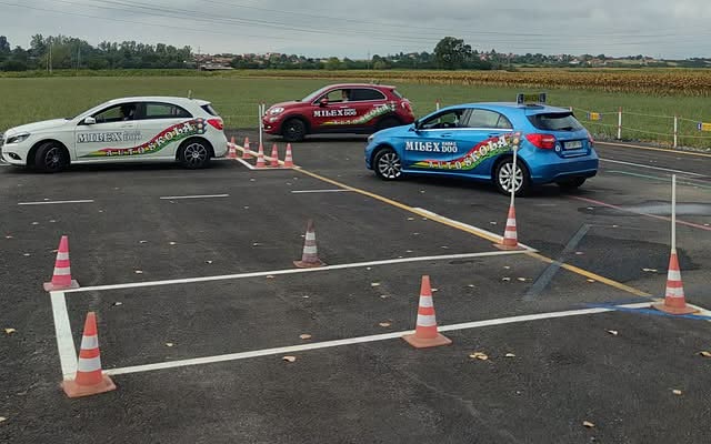 Tri automobila Auto škole Milex na poligonu, između čunjeva.